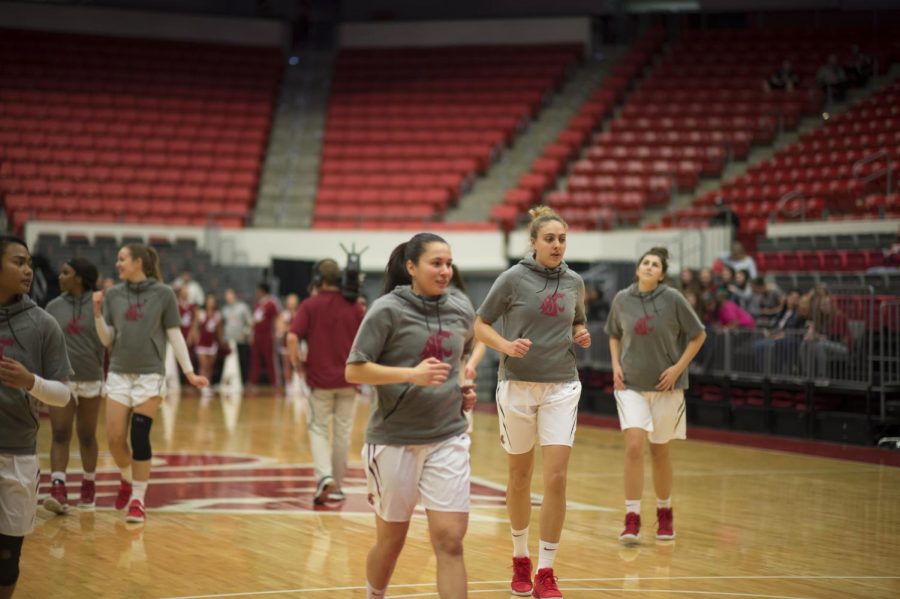 WSU womens basketball players warm up right before a game against California Thursday at the Beasley Coliseum. Most of seats available for attendees are empty.