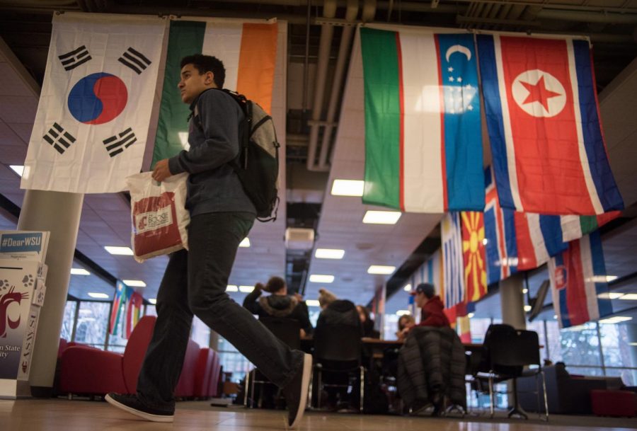 Mark Maben heads out of the CUB Thursday. Flags from around the world hang behind him in celebration of International Education Week, a week of cultural events sponsored by the International Students Council.