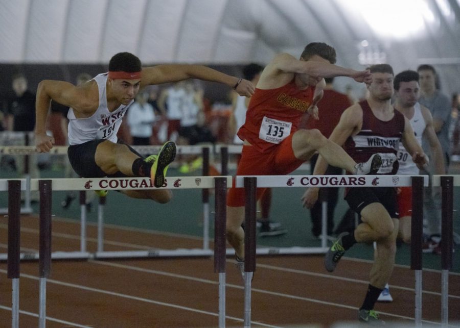 Junior hurdler Christapherson Grant, left, clears the hurdles as he competes in a heat during the Cougar Indoor on Feb. 3.