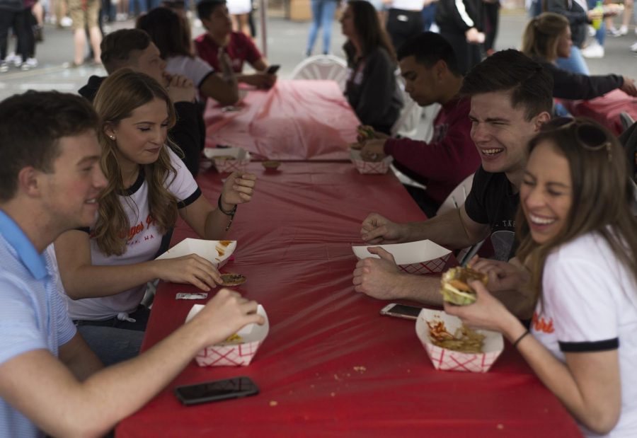 Greek students socialize while eating during the Pi Beta Phi’s Pi Burger Phri event, which was held in April 2017.