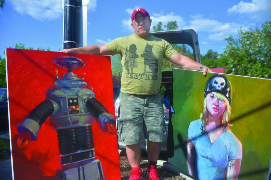 Henry Stinson, a local artist who has a painting studio in Pullman, holds some of his oil on canvas paintings that will be featured at the Neill Public Library during the ArtWalk.