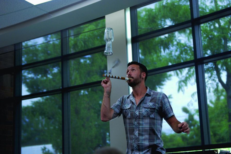 Matt Baker attempts to balance a vase on top of a balloon during a show at the Neill Public Library on Tuesday.