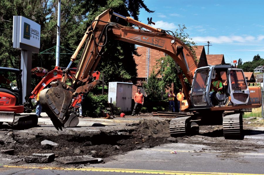 Workers from the Washington State Department of Transportation use an excavator to remove railroad tracks on Grand Avenue in Pullman on Monday.
