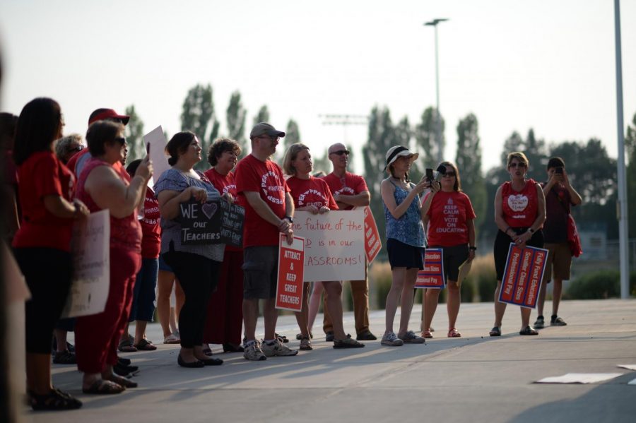 Pullman teachers listen to a speaker during their rally calling for higher salaries in front of Pullman High School before a Pullman School District Board meeting Wednesday night. Bargaining negotiations came to a halt in late July.