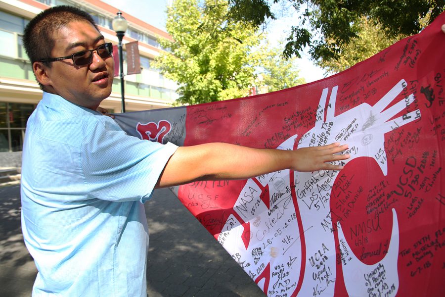 Post-graduate Jinfeng Ma points out the signature he received from astronaut Samuel Durrance during his journey across the United States this past summer.