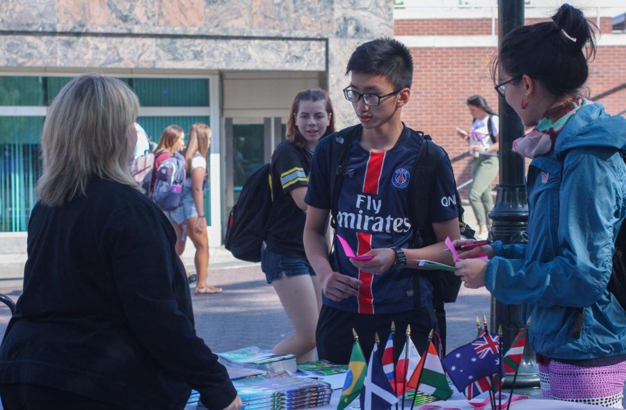 Kim Tulman, left, director of university relations University Studies Abroad Consortium at WSU, shows WSU junior Mike Chan, center, and sophomore Chia-Chen Lee opportunities to study abroad Wednesday at the Global Learning Fair. 