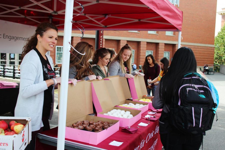 Center for Civic Engagement employees hand out cupcakes and buttons for the CCE 25th Anniversary on Glen Terrell Mall on Monday.