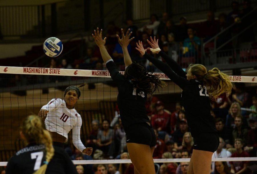 Then-junior outside hitter Taylor Mims attempts to spike the ball past a pair of Colorado defenders Oct. 6 at Bohler Gym.