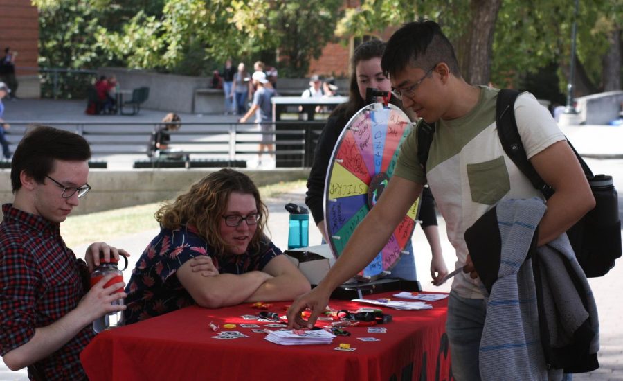 Chemical engineering major Elyas Alnamnakani picks up a flyer for STAGE Student Theatre’s improv comedy show at Glenn Terrell Mall on Wednesday.