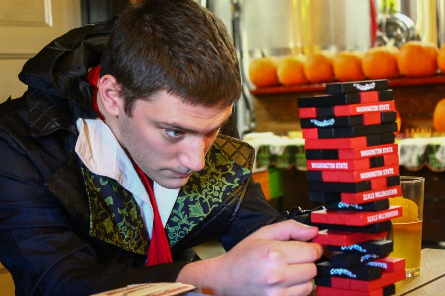 Zachary Brown, a fifth-year senior double majoring in Asian studies and Chinese language, plays a mini set of Jenga at the Paradise Creek “Booery” Halloween Party at the brewery’s Trailside Taproom on Saturday afternoon.