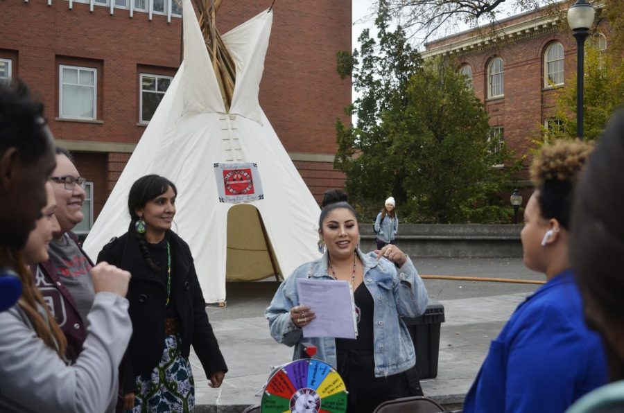 Faith Price, Native American Programs assistant director, left, and MyKel Johnson, senior communication
major, right, educate students about Native American history Monday on Glenn Terrell Friendship Mall.