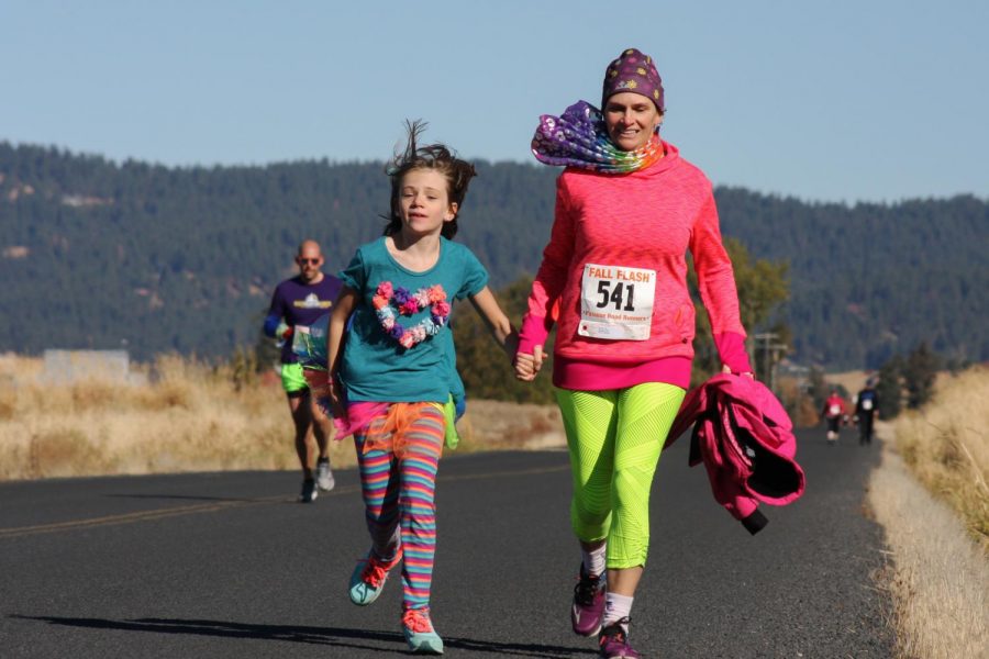 Emily Spellman, right, and her daughter Maya reach the end of the 5K run for the Fall Flash of the Palouse event Sunday in Moscow. Emily won a Flashy Award for donning bright attire after finishing the race with a time of 44:40.