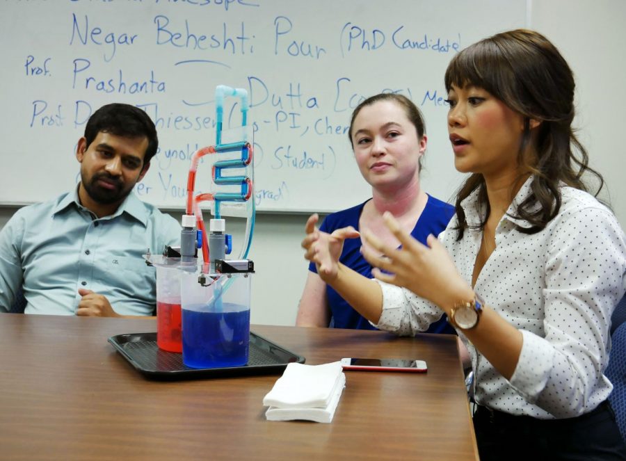 Doctoral candidate Aminul Islam Khan, left, and doctoral students Olivia Reynolds, middle, and Kitana Kaiphanliam, right, describe the double pipe heat exchanger Friday at the Voiland College.