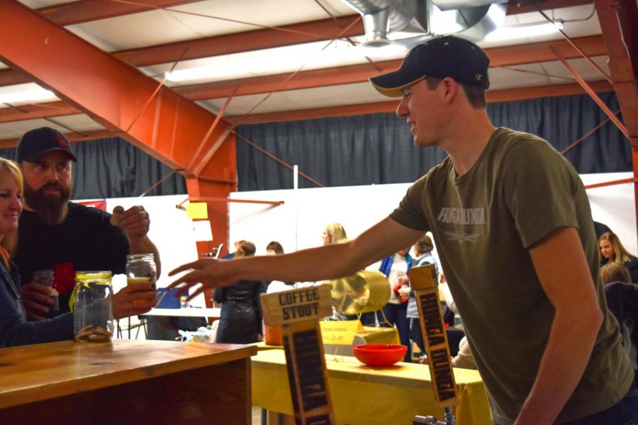 Anthony Lambregts, an employee at Hunga Dunga Brewing, serves one of the two popular brews for an event member at Brewersfest on Saturday in Moscow.