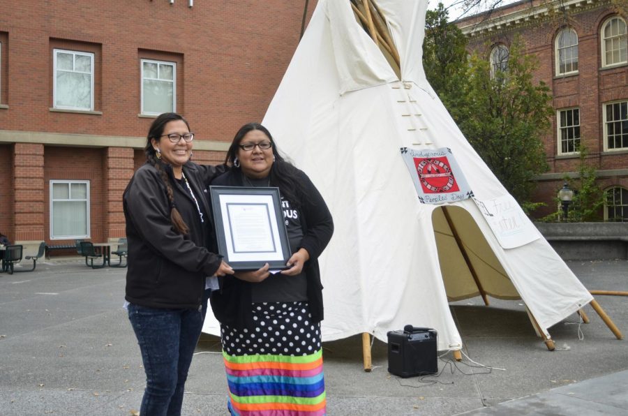 From left: Tipiziwin Tolman, teacher at Lakhol’iyapi Wahohpi, poses with Ku-Ah-Mah Co-chair Chantel Hill, in front of a tipi in celebration of Indigenous People’s Day on Oct. 8.