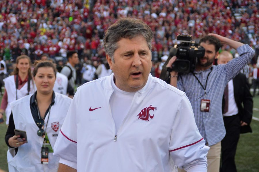 WSU Head Coach Mike Leach runs out onto the field with his team before the game against University of Oregon on Oct. 20, 2018, at Martin Stadium. 