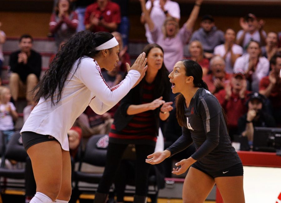 Sophomore outside hitter Penny Tusa, left, and junior libero Alexis Dirige high-five one another after a successful rally in the game against University of California, Los Angeles, on Oct. 21 in Bohler Gym.