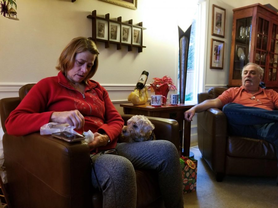 Mint editor Emma Ledbetter opens presents on Christmas morning with her parents. Emmas mother, Melissa, unwraps a palm tree ornament while her father and dog look on.