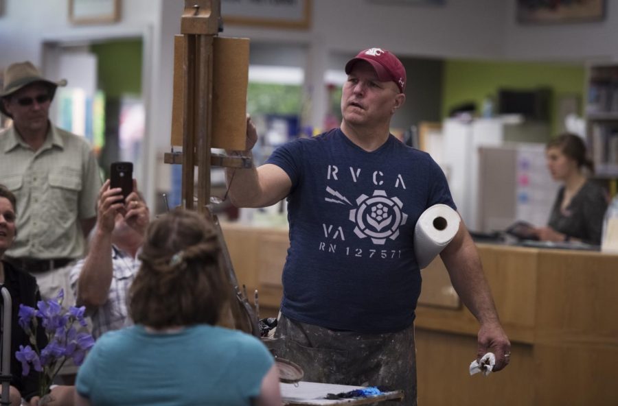 Henry Stinson, an art teacher at Colfax High School, creates a live portrait painting during the Pullman ArtWalk on May 19 at Neill Public Library. Joanna Bailey, Neill Public Library director, says the event grew throughout the years.