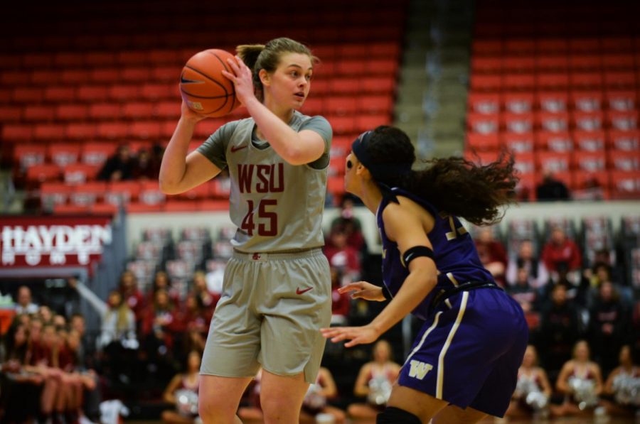 WSU redshirt junior forward Borislava Hristova keeps the ball away from UW junior forward Mai-Loni Henson Friday night at Beasley Coliseum. The Cougars hit the road today for their final road trip of conference play.