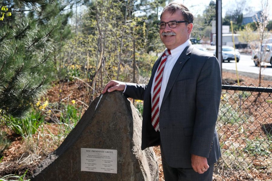 Outgoing Provost Daniel Bernardo poses by a plaque honoring him and past presidents of WSU on Tuesday at the Greenway Trailhead. 
