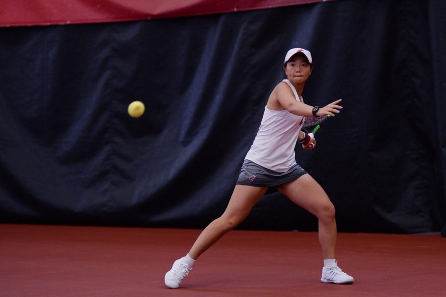 Freshman Yang Lee watches the tennis ball approach her racket during doubles play on April 12 at Hollingbery Fieldhouse.