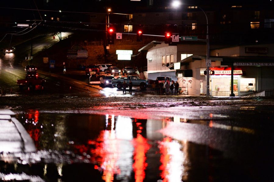 Excess rain water runs down the street, causing both drivers and pedestrians to reconsider their routes, on Tuesday night at the intersection of Grand Avenue and Stadium Way.