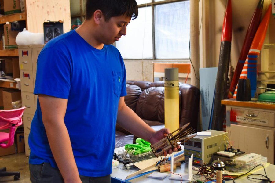 Bryson Jaipean, WSU Aerospace Club Vice President, holds part of a rocket designed
to go 10,000 feet in the air. The rocker is in the construction process.