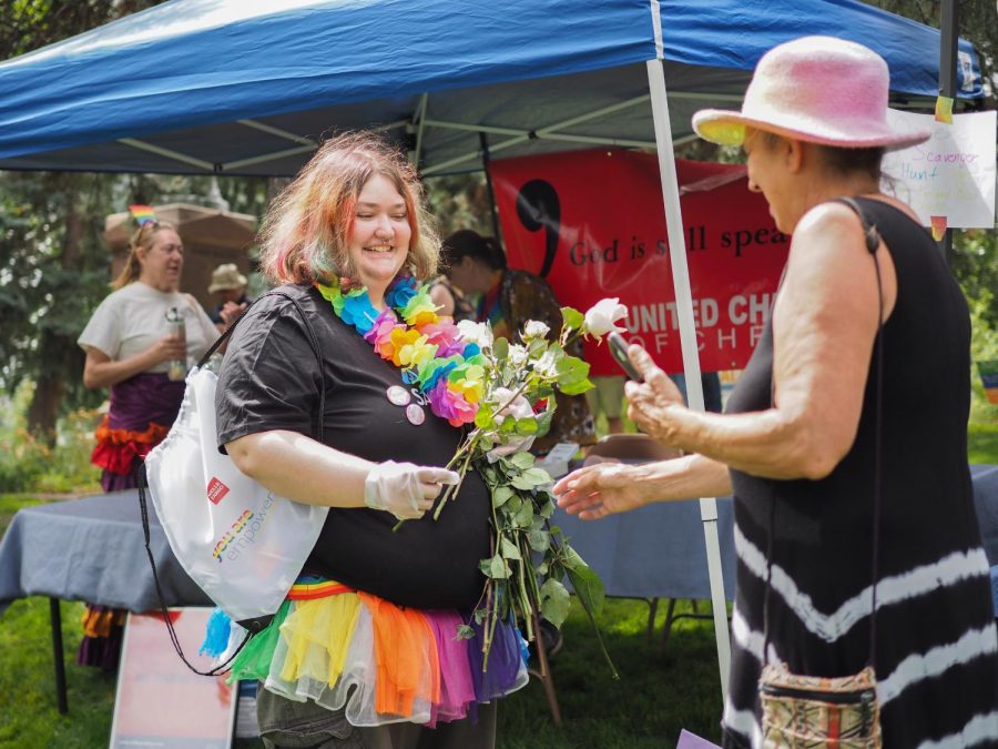 Colten Ford, an event specialist for Safeway, hands out fresh flowers to festival attendees at Palouse Pride.