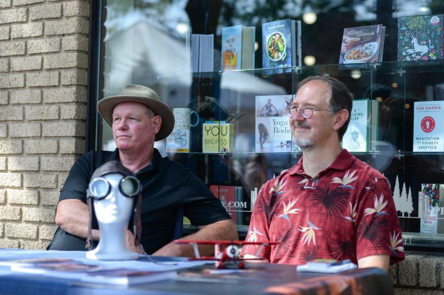 Mark Ready, religious fantasy fiction author, and adventure fiction author Guy Worthey sit at a table during the farmers’ market on Saturday outside BookPeople of Moscow.