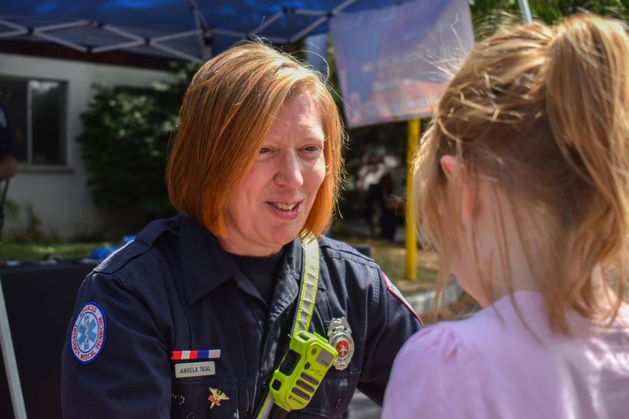 Pullman firefighter Angela Teal hands out stickers to children visiting the Pullman Fire Department booth Saturday afternoon at the National Lentil Festival in Reaney Park. 
