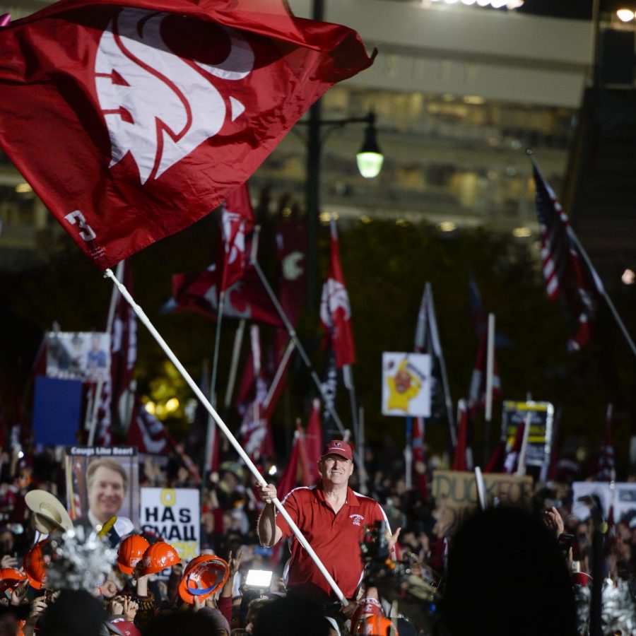 Tom Pounds, founder of the Ol’ Crimson Booster Club, waves Ol’ Crimson as fans cheer during ESPN’s College GameDay broadcast on Oct. 20 in Pullman. 