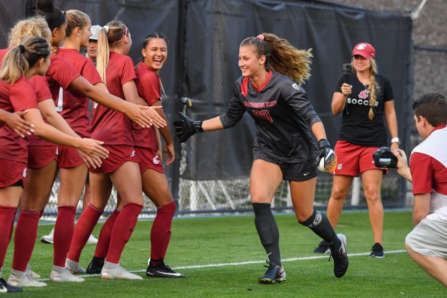 Graduate student goalkeeper Ella Dederick high-fives her teammates. Dederick returned for a sixth year to help herself reach her professional soccer goals of one day making it to the national stage.