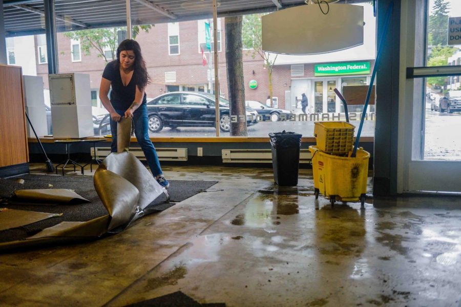 Shelby Sater, manager at Thomas Hammer Coffee Roasters, tears up the carpet after water flooded into the coffee shop Tuesday evening in downtown Pullman. Other local businesses were also affected along the intersection of Main Street and Southeast Pine Street.
