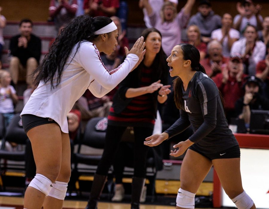 Junior outside hitter Penny Tusa, left, and senior libero Alexis Dirige high-five one another after a successful rally in the game against University of California, Los Angeles, on Oct. 21 in Bohler Gym.