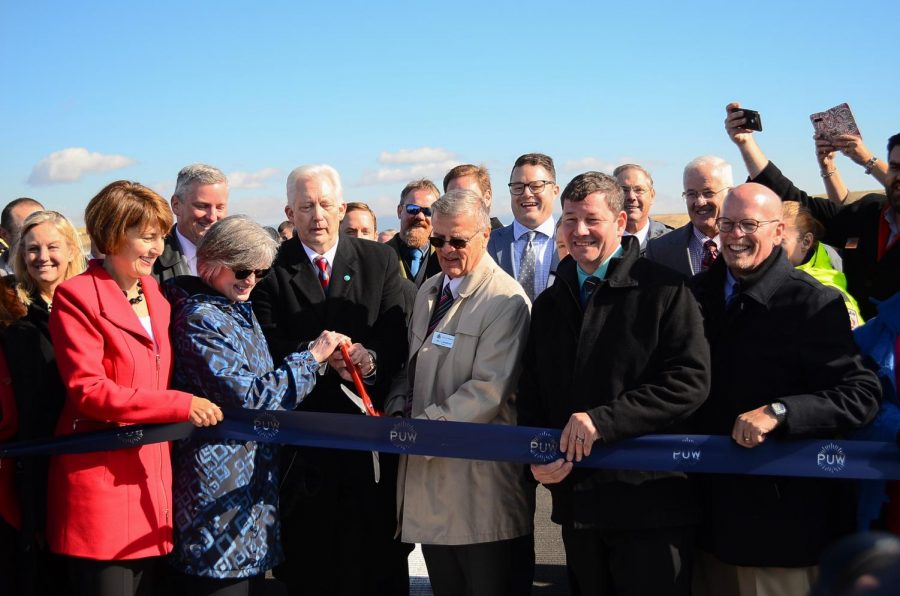 Karen Miles, civil engineering project manager for the FAA, Pullman Mayor Glenn Johnson and Moscow Mayor Bill Lambert cut the ribbon for the reopening of the Pullman-Moscow Regional Airport on Thursday. 