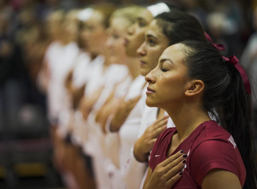 Alexis Dirige stands with her team as the WSU band plays the national anthem before the Cougars upset the University of Washington Huskies on Sept. 25 at Bohler Gym. 