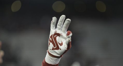 A WSU player holds up three fingers in honor of Tyler Hilinski, a former WSU quarterback who died by suicide in January 2018. 
