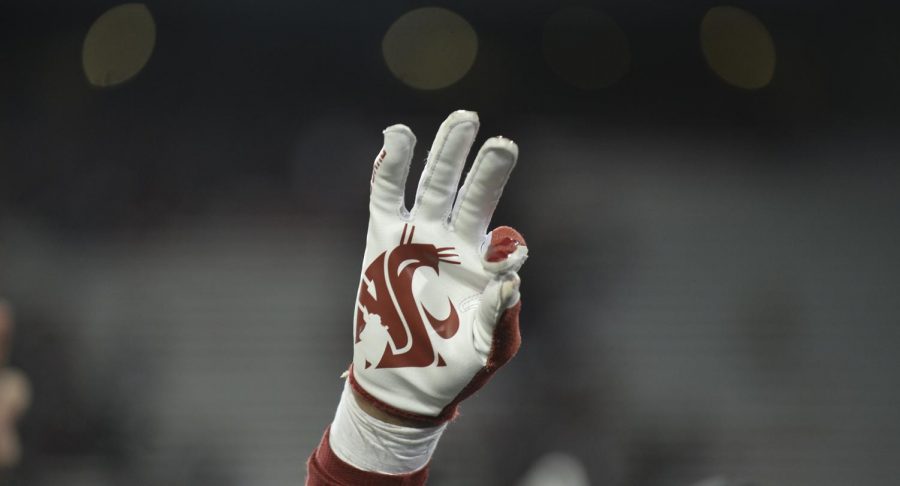 A+WSU+player+holds+up+three+fingers+in+honor+of+Tyler+Hilinski%2C+a+former+WSU+quarterback+who+died+by+suicide+in+January+2018.+