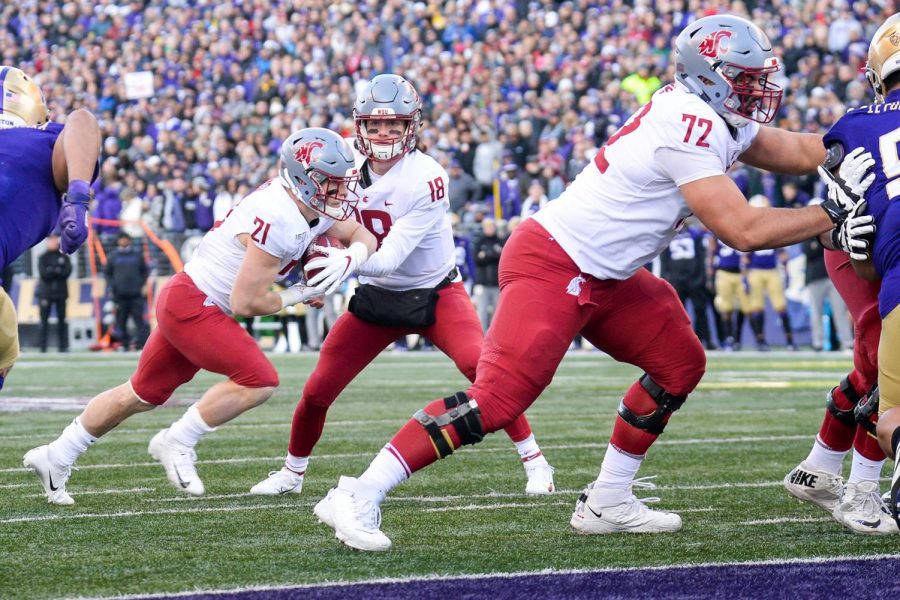 Senior quarterback Anthony Gordon hands the ball off to Sophomore running back Max Borghi who scores the first touchdown of the Apple Cup Friday afternoon at Husky Stadium.