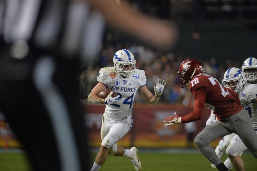 Air Force junior running back Kadin Remsberg runs downfield shortly before redshirt junior safety Skyler Thomas makes the tackle on Friday night at Chase Field. The Cheez-It Bowl game in Phoenix, Arizona resulted in a 31-21 loss for the Cougars.