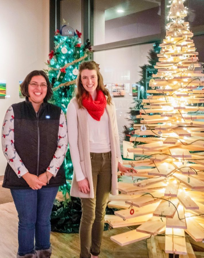 Tomara Jackson, left, stands with Hannah Croskey and the wood-crafted, award-winning tree she designed for Pullman Building Supply. 