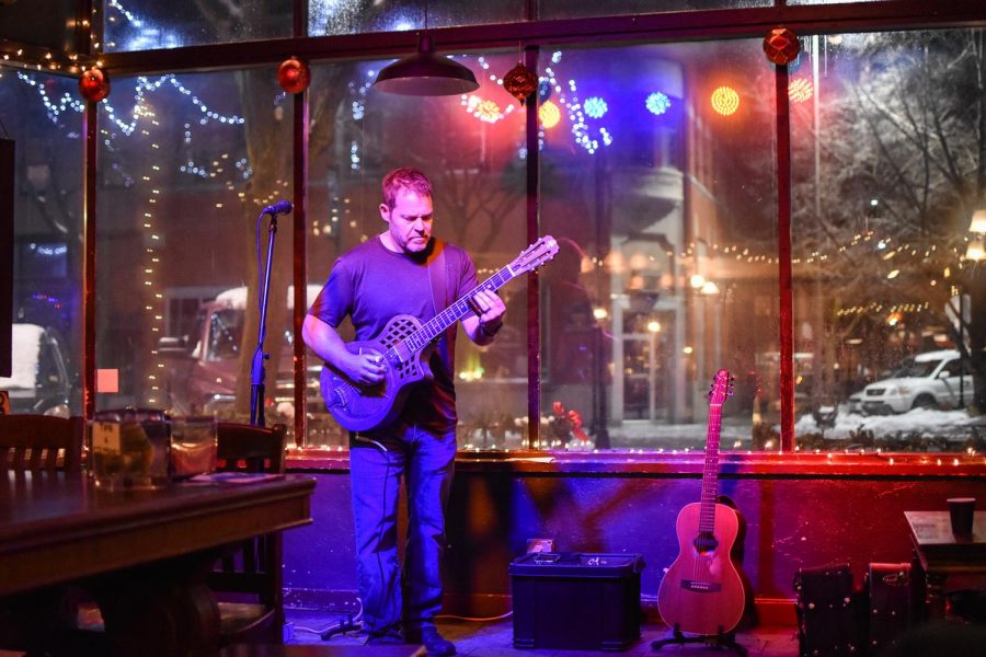 Marty Ytreberg, physics professor at University of Idaho, performs delta blues songs on a slide guitar Saturday night at Bucers Coffeehouse and Pub in Moscow. Ytrebergs stage name is Delta G, a name he came up with based on his work measuring Gibbs free energy, or delta G. 