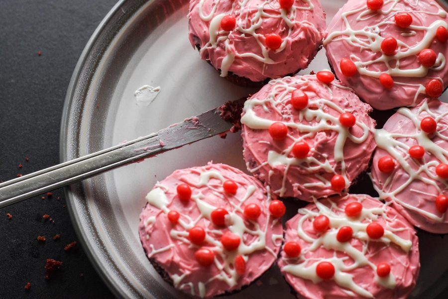 The cupcakes are stuffed with pink frosting, then frosted, drizzled and topped with candies.