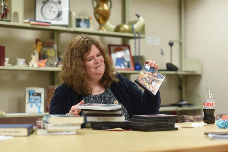 Erica Nichol, a humanities reference librarian, holds up the Wonder Woman DVD because it is one of the more well known feminist films on Tuesday afternoon in Terrell Library.