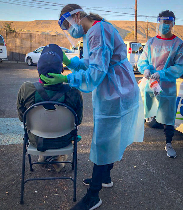 Testing is being done at a mobile dental clinic. People can drive up and receive testing from medical professionals who are outside the clinic. 