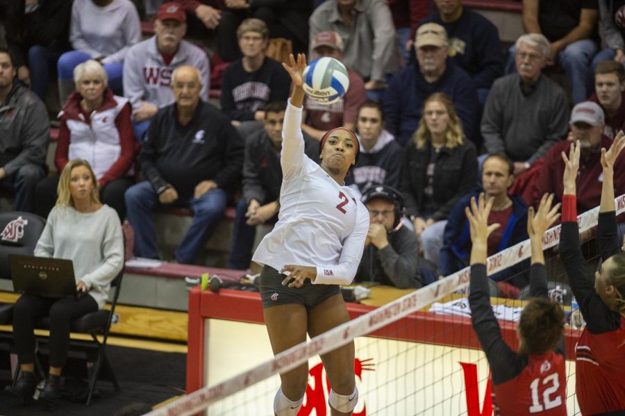Redshirt+sophomore+outside+hitter+Kalyah+Williams+jumps+up+for+a+spike+on+top+of+defenders.