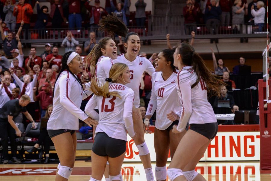 The WSU women's volleyball team celebrates on-court after scoring the 18th and winning point against Utah on Sept. 28, 2018 in Bohler Gym.