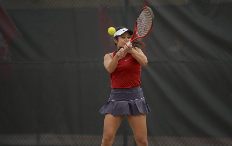 Sophomore Pang Jittakoat makes a backhand return during a singles match against Arizona March 14 at the WSU Outdoor Tennis Courts.