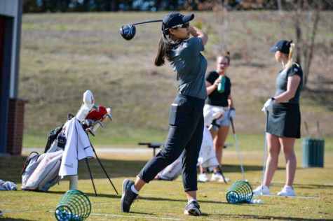 Junior Amy Chu warms up with some practice shots on the driving range.